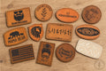 Custom engraved leatherette heat press ready hat patches in various shapes and colors