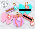 Initial coquette hair tie holder keychains and bag tags in colorful glossy acrylic