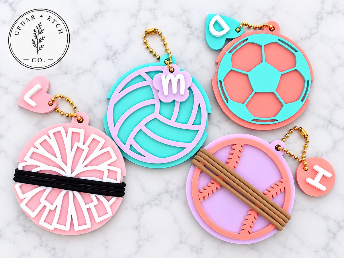 Personalized sports hair tie holder keychains and bag tags in volleyball, soccer, cheer and softball designs